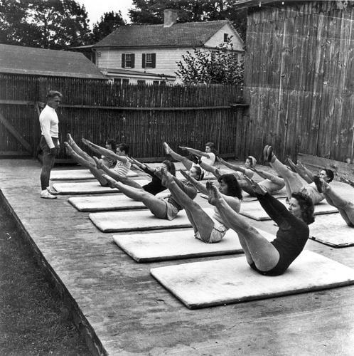 Joseph Pilates guidant un cours collectif au tapis, en extérieur